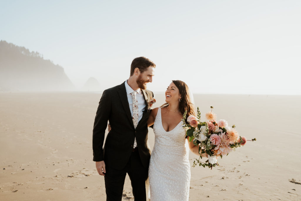 Andrew and Samantha (in suit and white dress) look at each other lovingly after eloping on the Oregon coast in September.